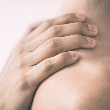 Hand on shoulder representing skin sensitivity support