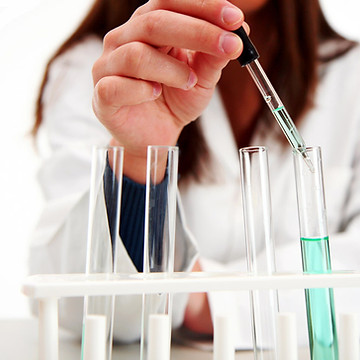 Scientist with test tubes representing progesterone compounding support