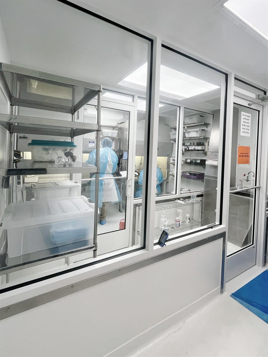 Sterile compounding team member working at a cleanroom hood
